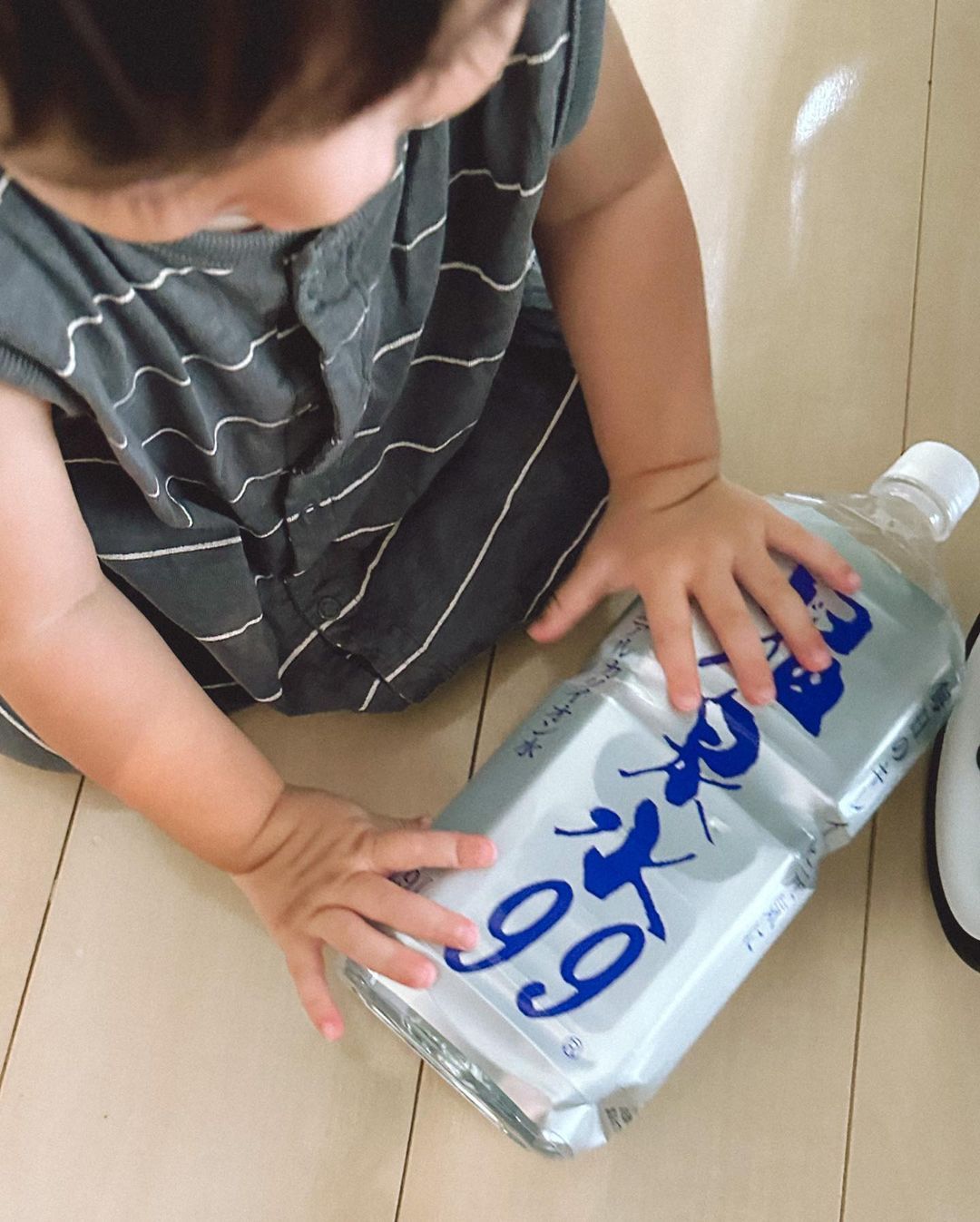 小さな女の子が温泉水99の空きペットボトルをたたんでリサイクルする様子