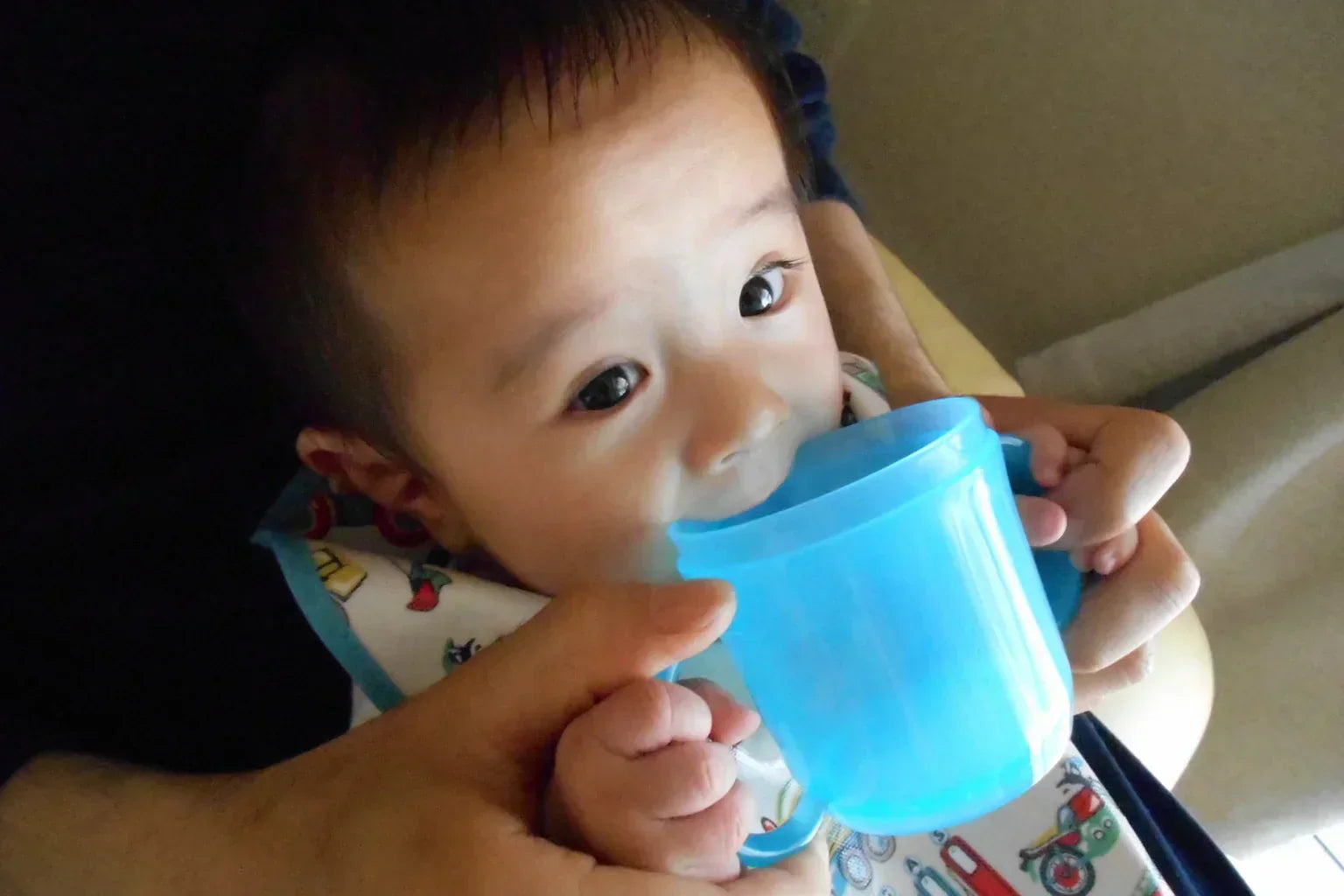 A Japanese baby drinking soft water from a blue cup, ideal for a family hydration article by ONSENSUI99