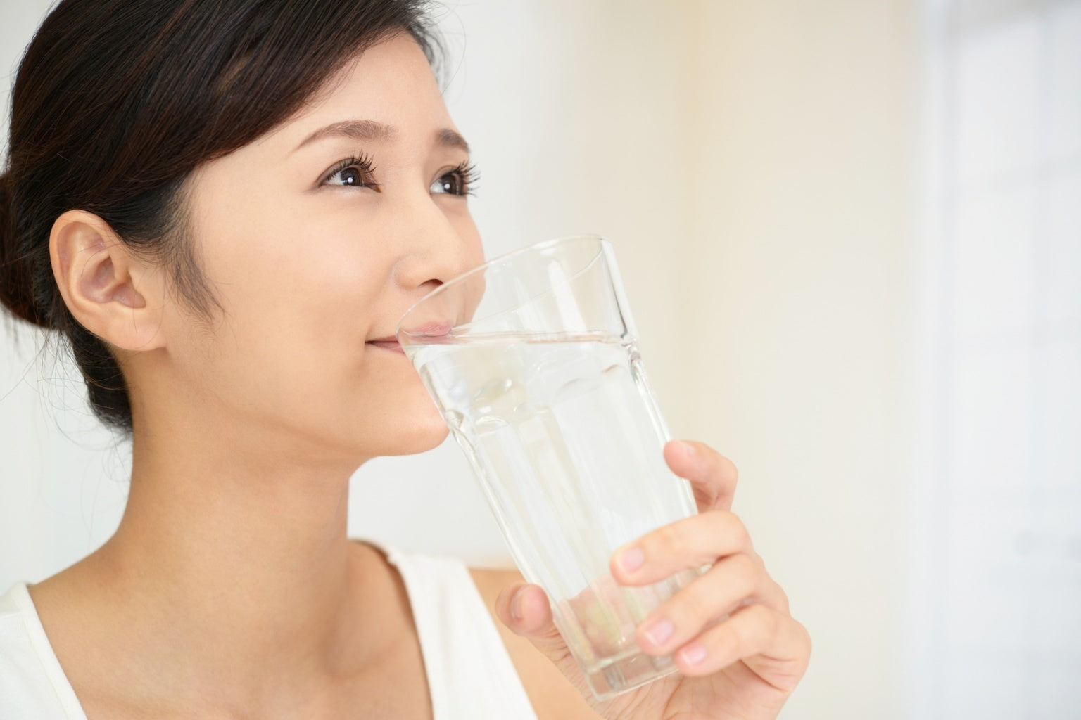Woman drinking water representing beauty hydration lifestyle and healthy skincare routine