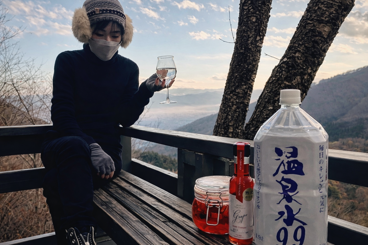 アウトドアで温泉水99を使いフルーツジュースを楽しむ女性