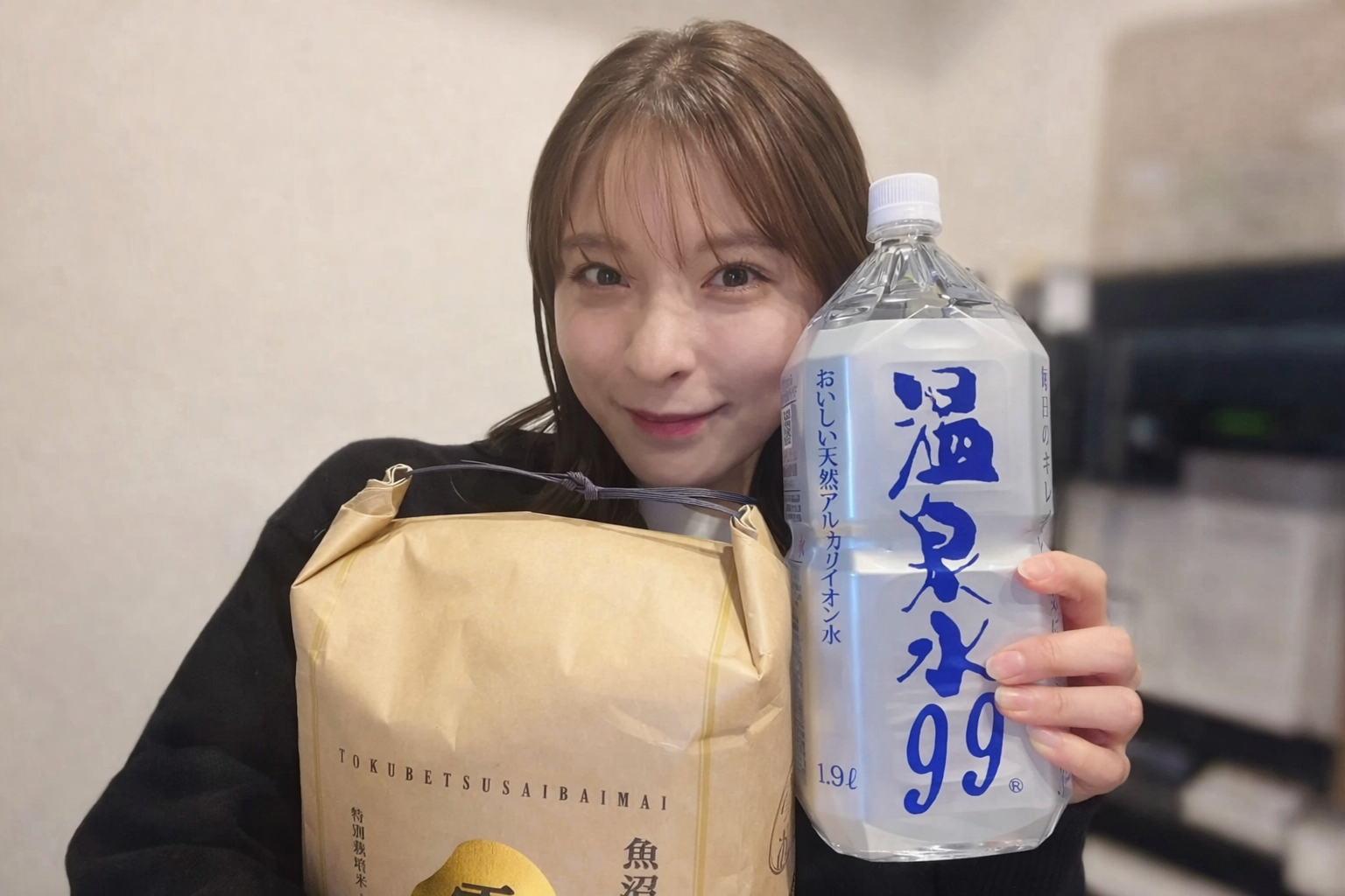 女性が米袋と温泉水99を持つ姿 ご飯を美味しく炊く水の象徴