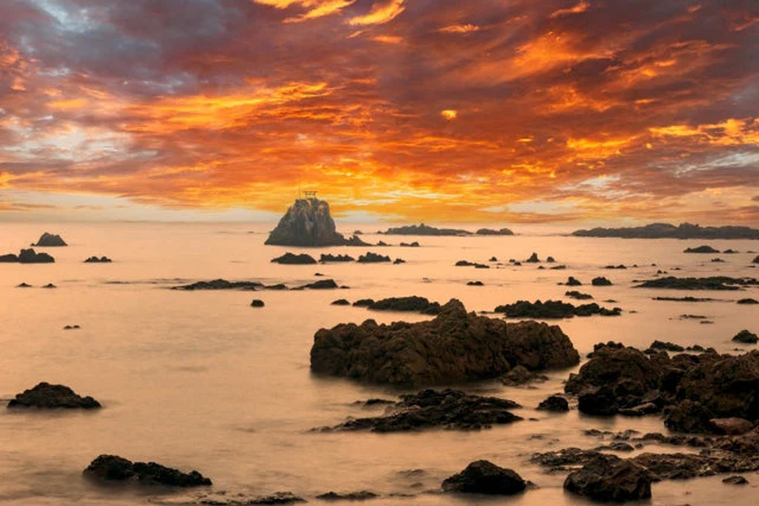 阿久根のうたせ岩に沈む夕陽。海と光が調和する癒しの風景。