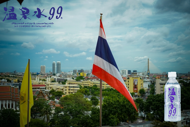 タイ国旗とバンコク市街を背景にした温泉水99の公式ニュース画像(タイFDA正式許可取得のお知らせ)