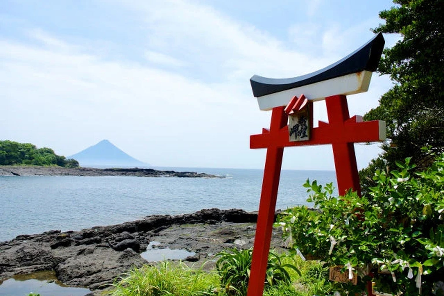 野間岬の赤い鳥居と海越しに望む開聞岳。祈りと自然が交わる南さつま市の象徴的風景。