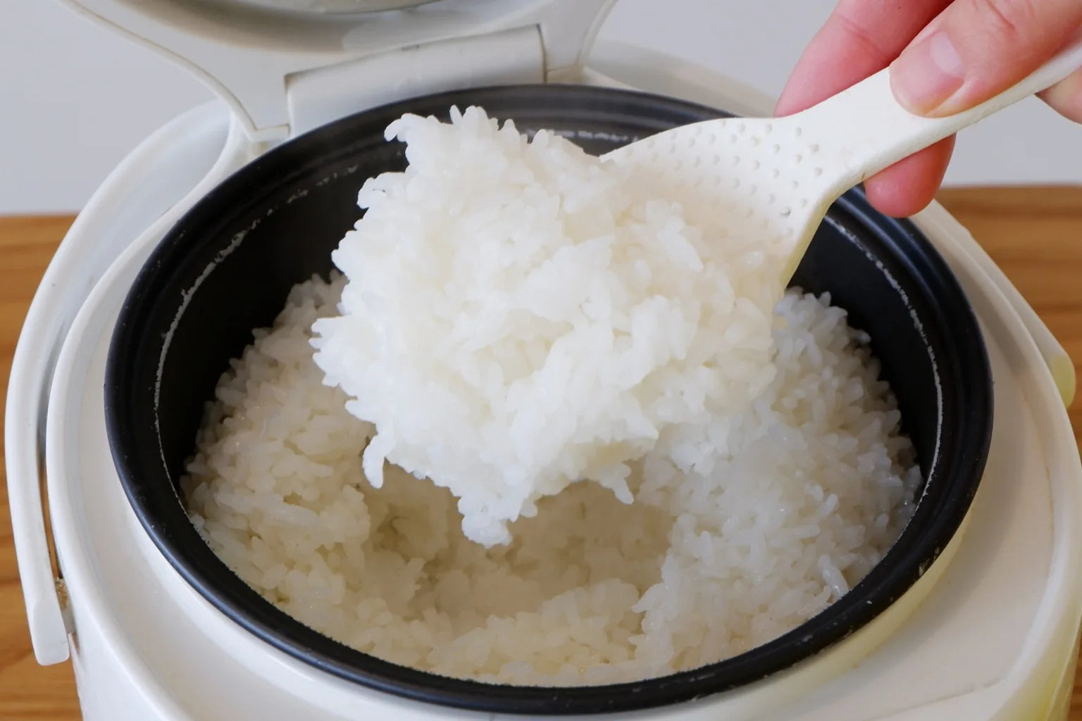 Fresh rice being served from rice cooker