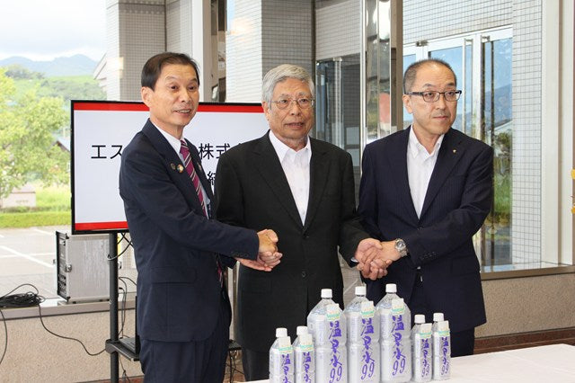 草間社長、垂水市長、鹿児島県関係者が立地協定締結後に握手を交わす様子