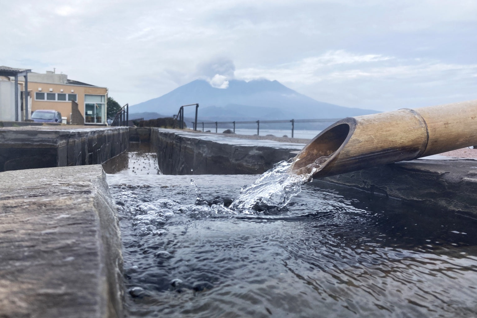 Hot spring water flowing in Tarumizu Kagoshima Japan with Sakurajima volcano in the background