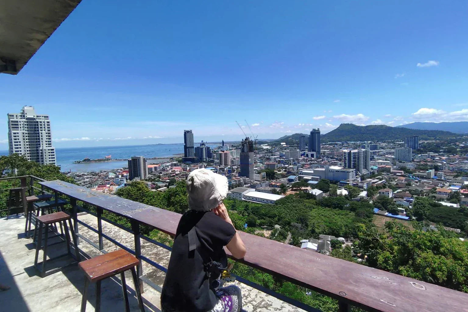 Woman overlooking a coastal city view in Thailand