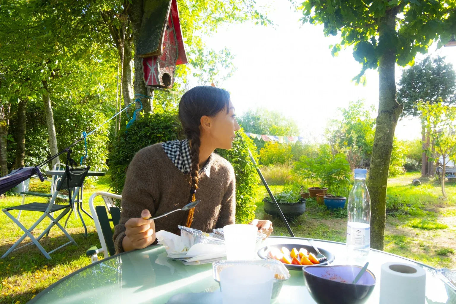 Woman enjoying a peaceful outdoor breakfast surrounded by nature during slow life travel