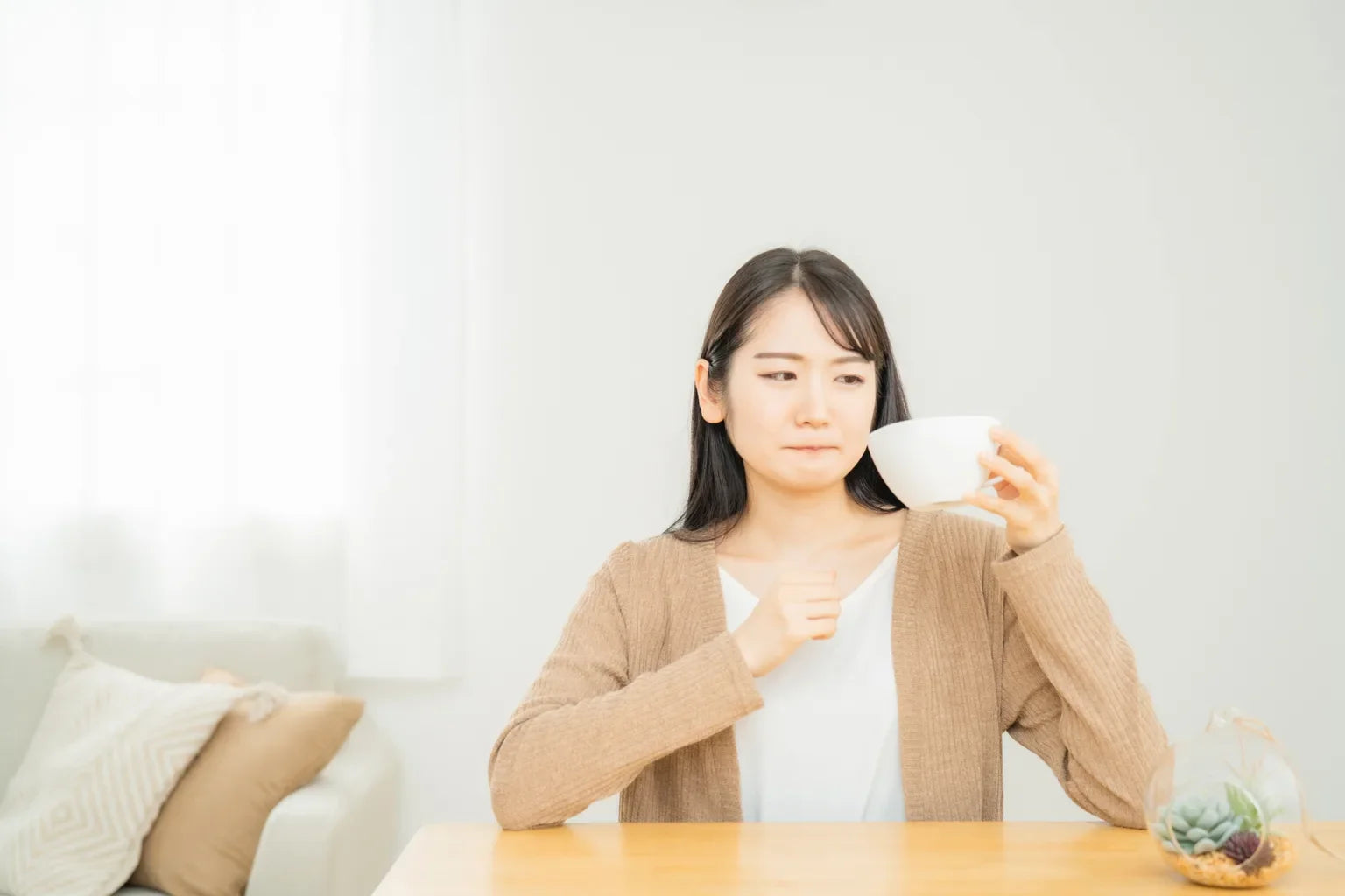 Woman reacting to unpleasant taste of drinking water illustrating concern about emergency stored water quality