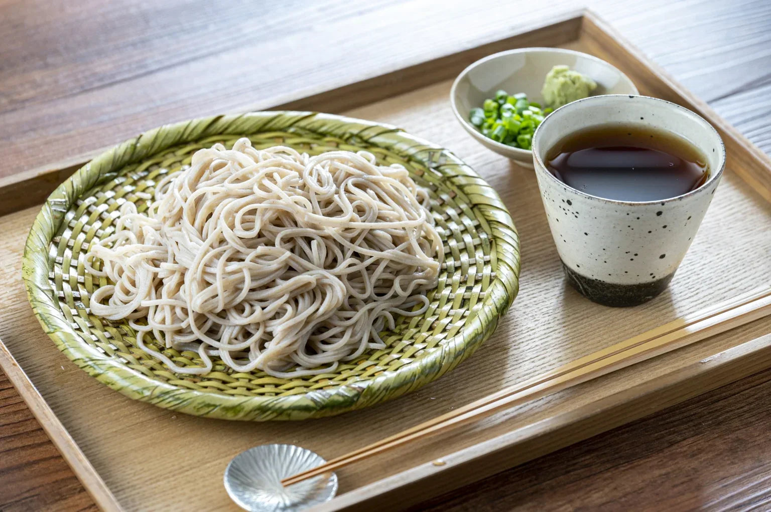 Traditional Japanese zaru soba served with dipping sauce and condiments.
