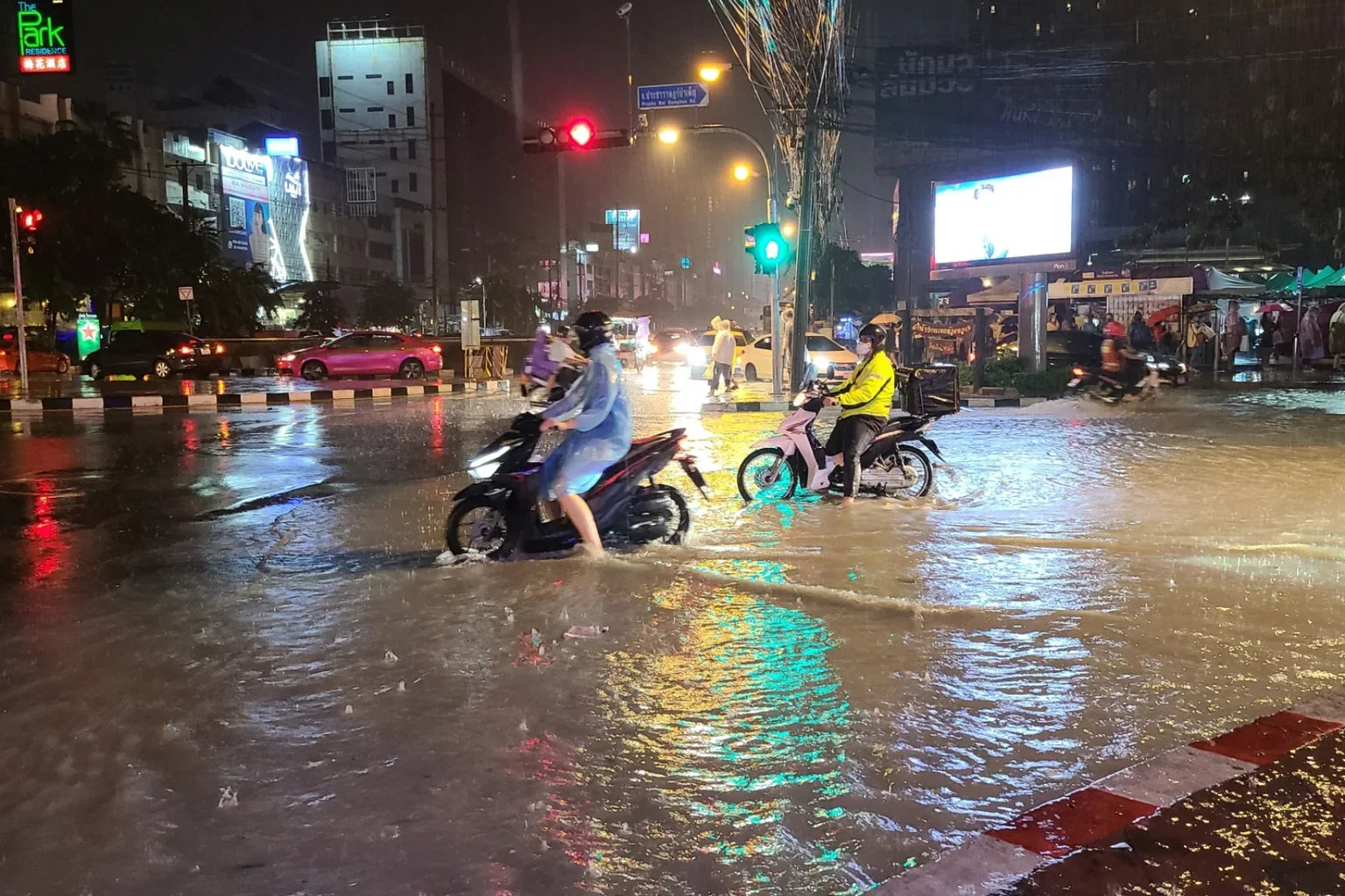 Bangkok flooded street at night during rainy season in Thailand with motorcycles and traffic