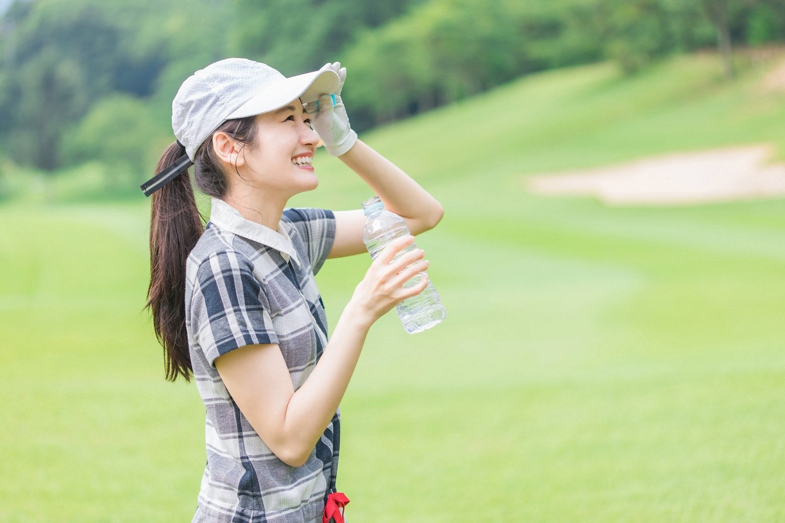 Female golfer staying hydrated on a hot golf course