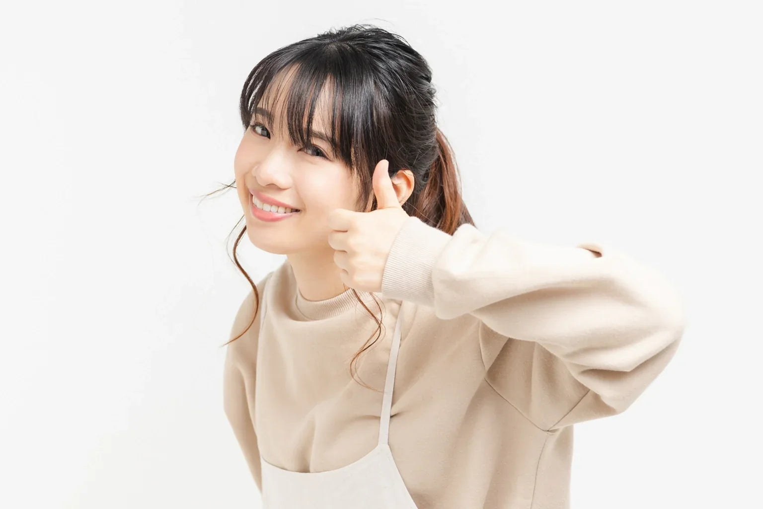 A smiling Japanese woman giving a thumbs-up for ONSENSUI99 soft water from Japan.