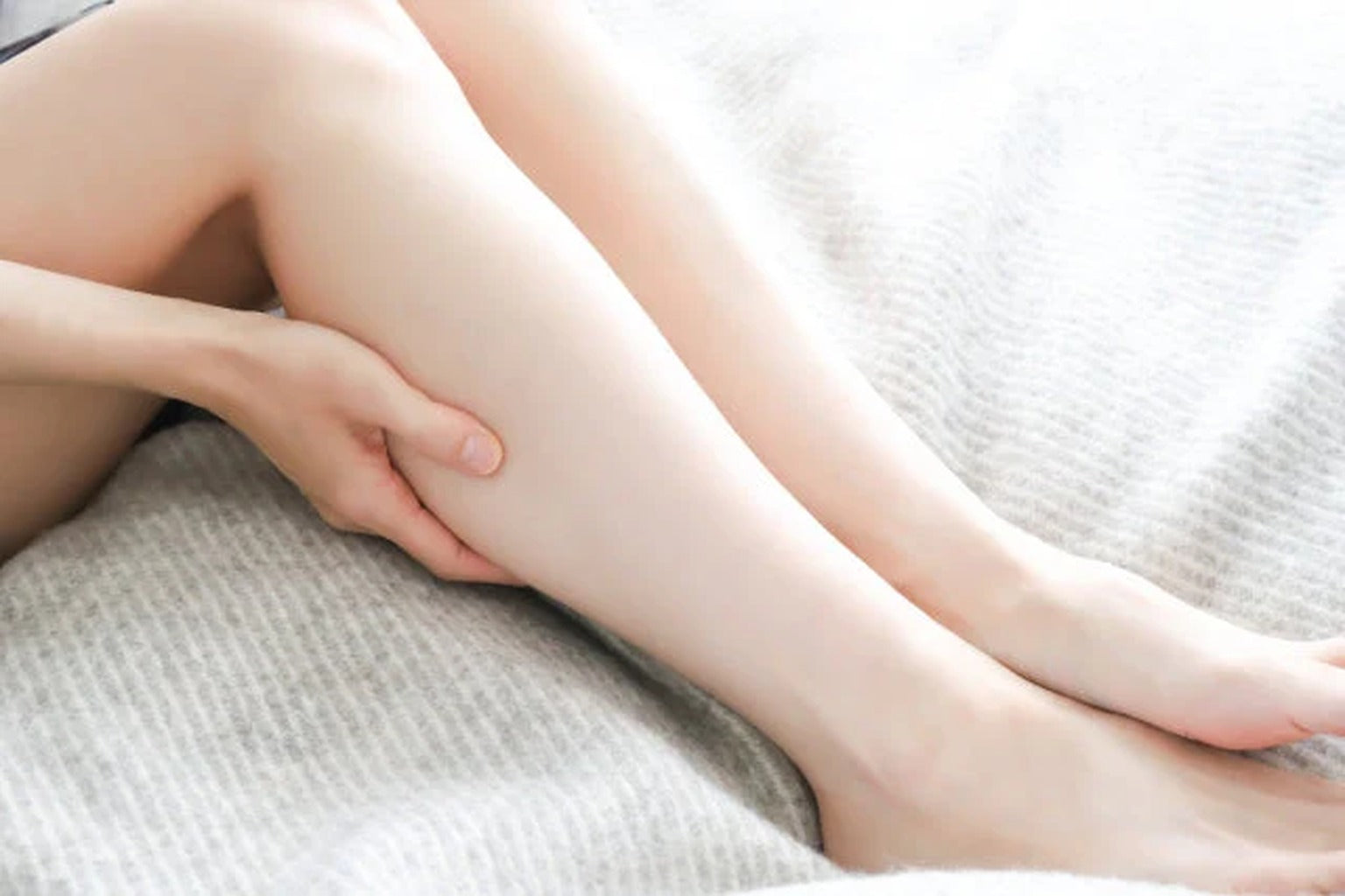 Woman massaging legs for circulation and hydration health concept