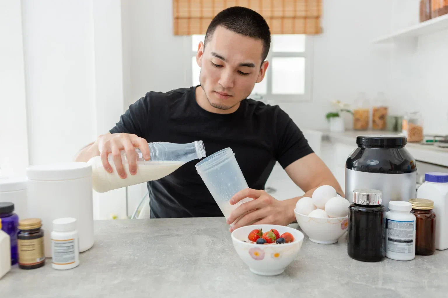 A man preparing a protein shake with water in a kitchen, illustrating mixing protein with water for daily use.