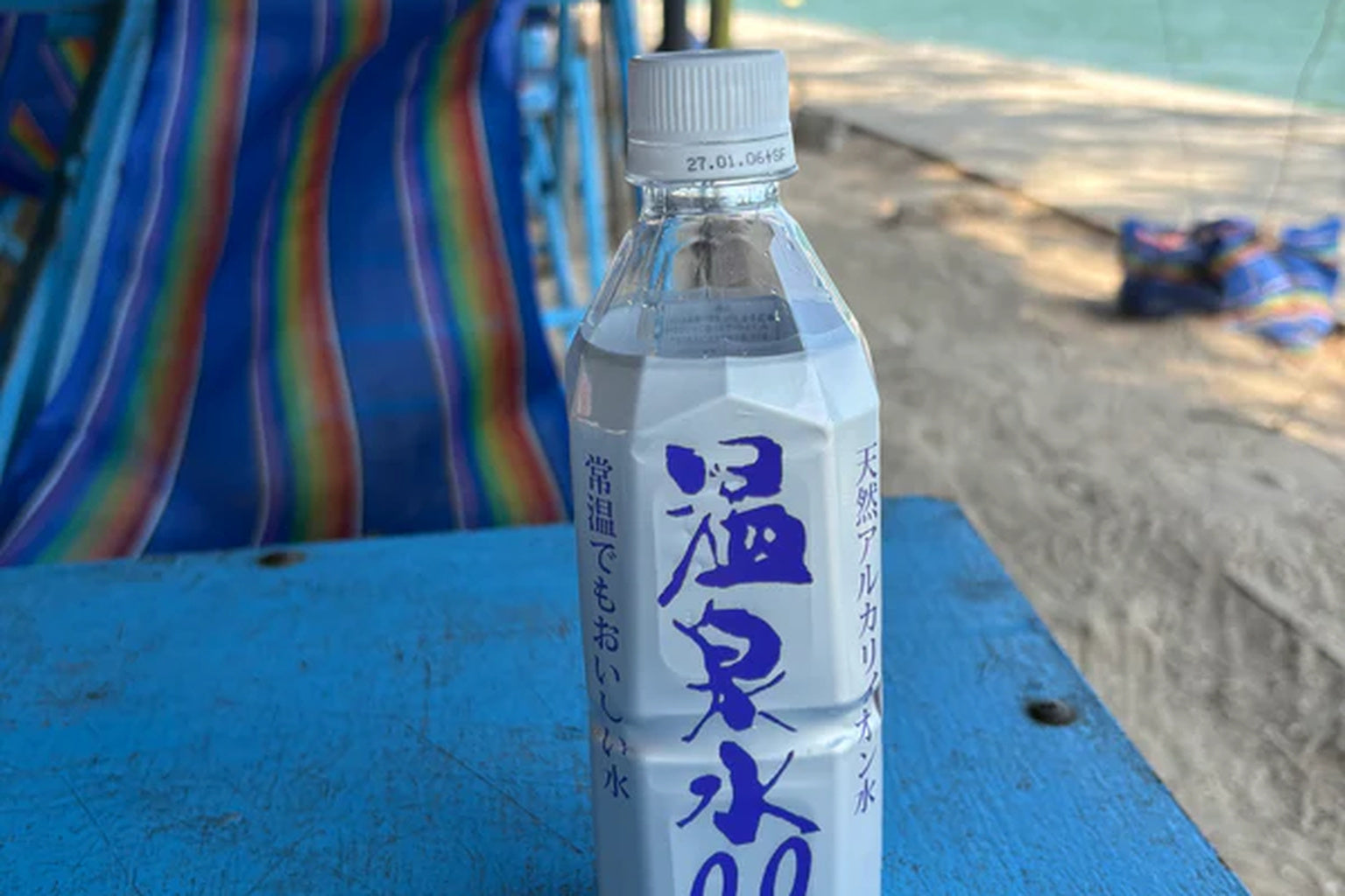 ONSENSUI99 Japanese alkaline soft water bottle at Bang Saen Beach in Thailand, ideal for refreshing hydration in a tropical climate.
