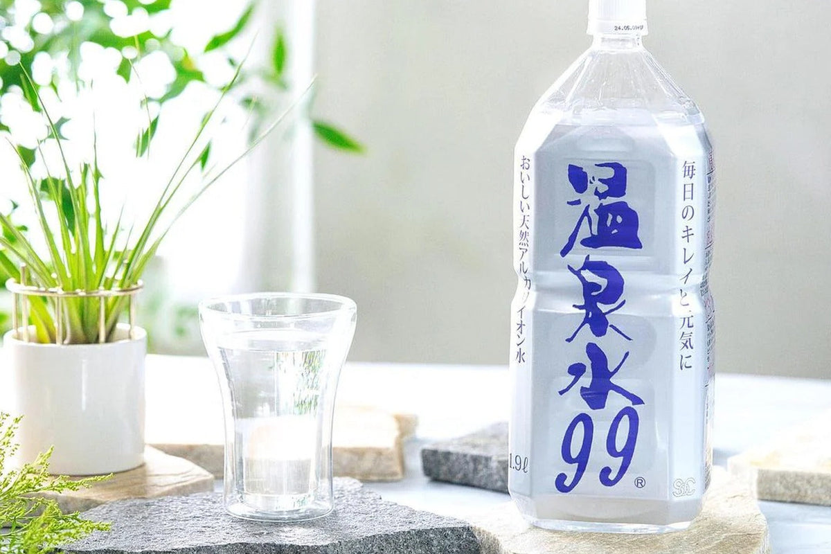 朝日が差す窓辺に置かれた温泉水99ボトルとグラス｜Onsen Water 99 Wellness Series