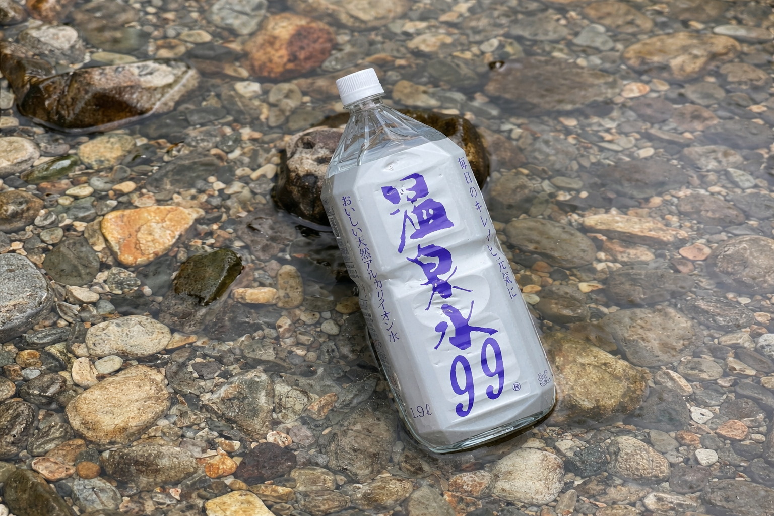 清流の中に置かれた温泉水99のボトル｜自然の清らかさとピュアな水を象徴