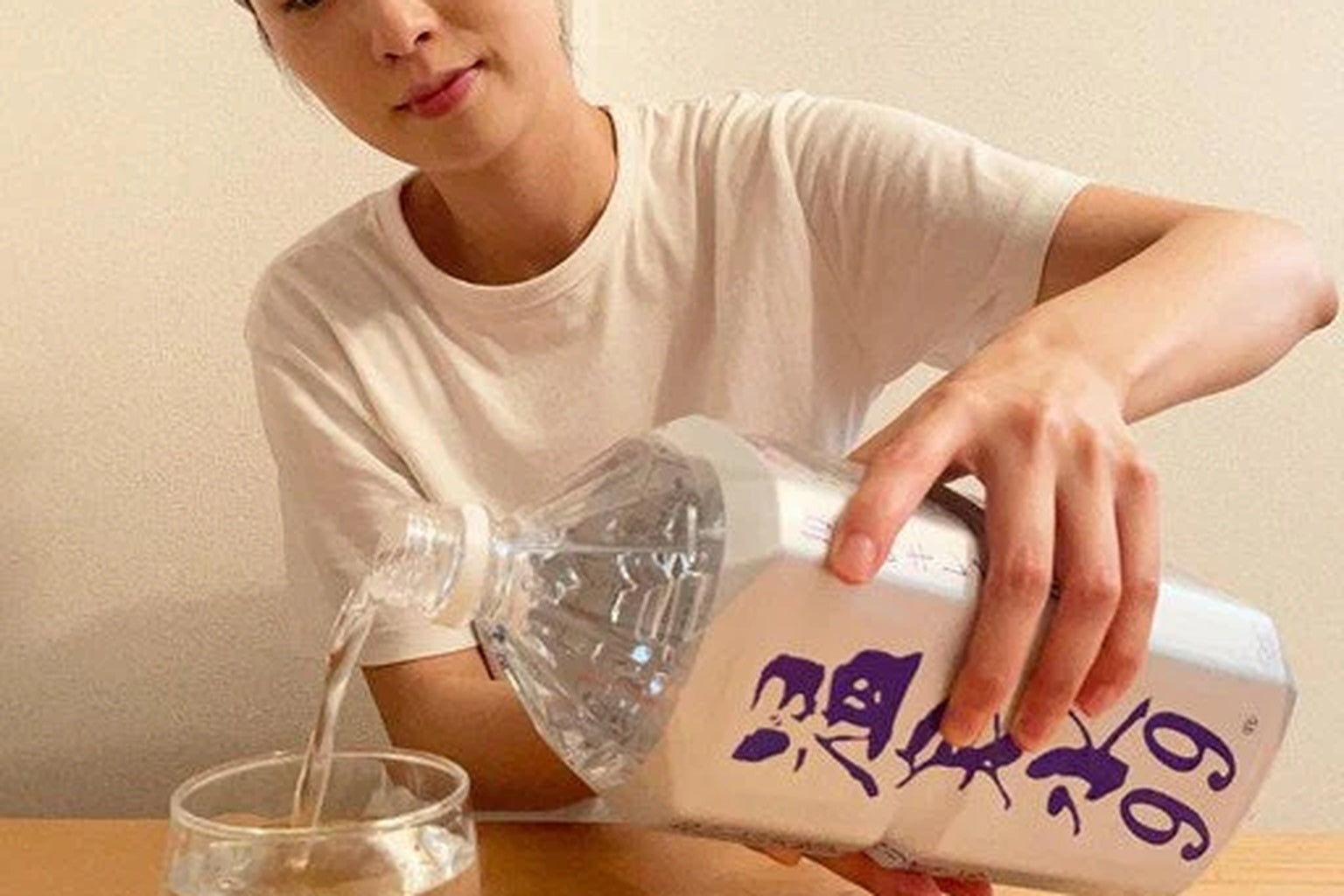 スキンケア後に温泉水99をグラスに注ぐ女性｜体の内側からうるおいを育てる“飲むスキンケア”の習慣