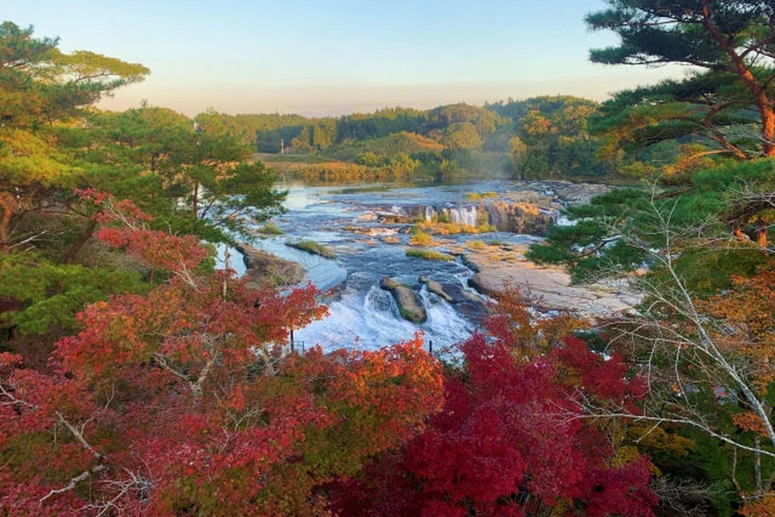 紅葉に包まれた曽木の滝。癒しと祈りの旅を締めくくる壮大な風景。