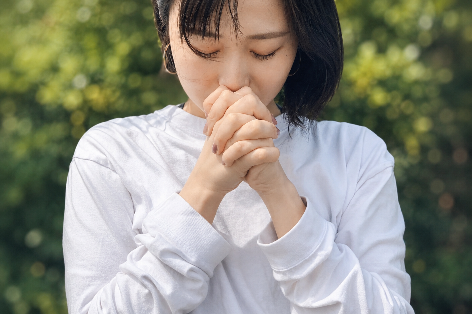 Woman praying quietly in nature inspired by Japanese wellness culture