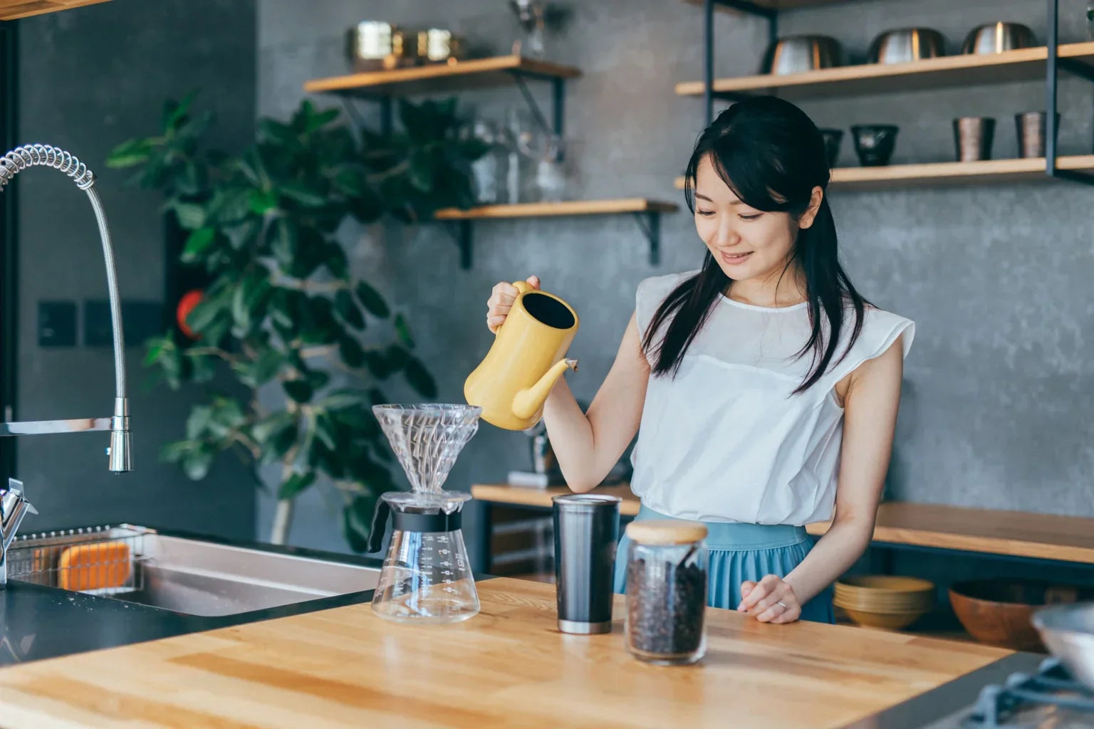 Woman brewing hand drip coffee with soft water at home