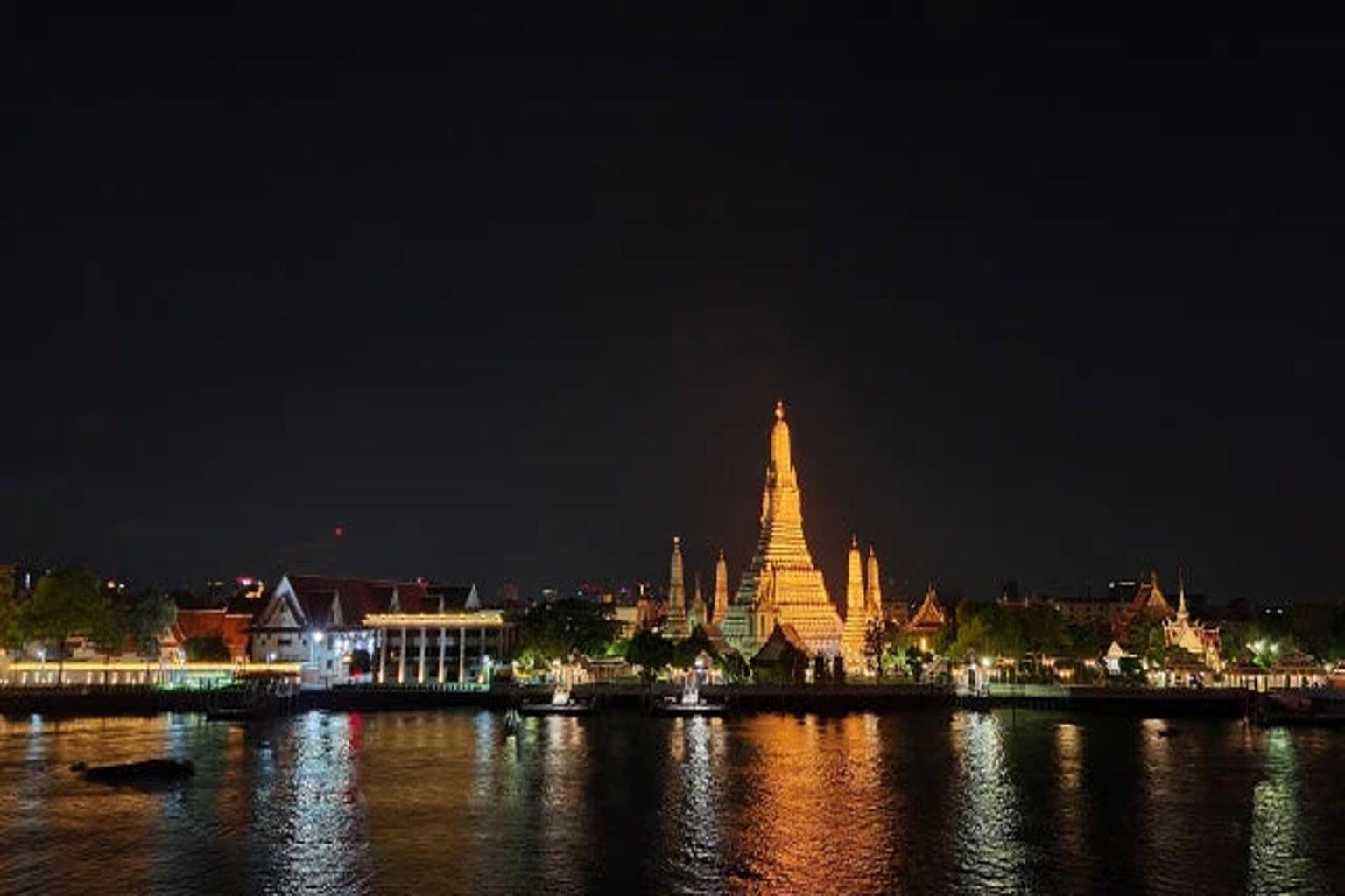 水面に映るワット・アルンの夜景。黄金の光がバンコクの夜を照らす