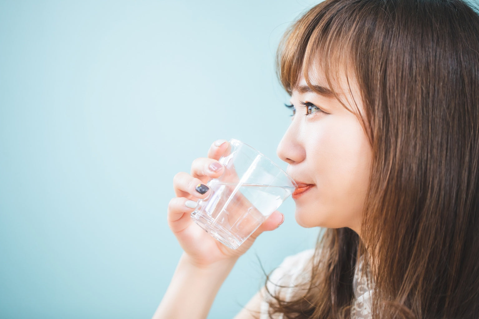 close up woman drinking glass of water