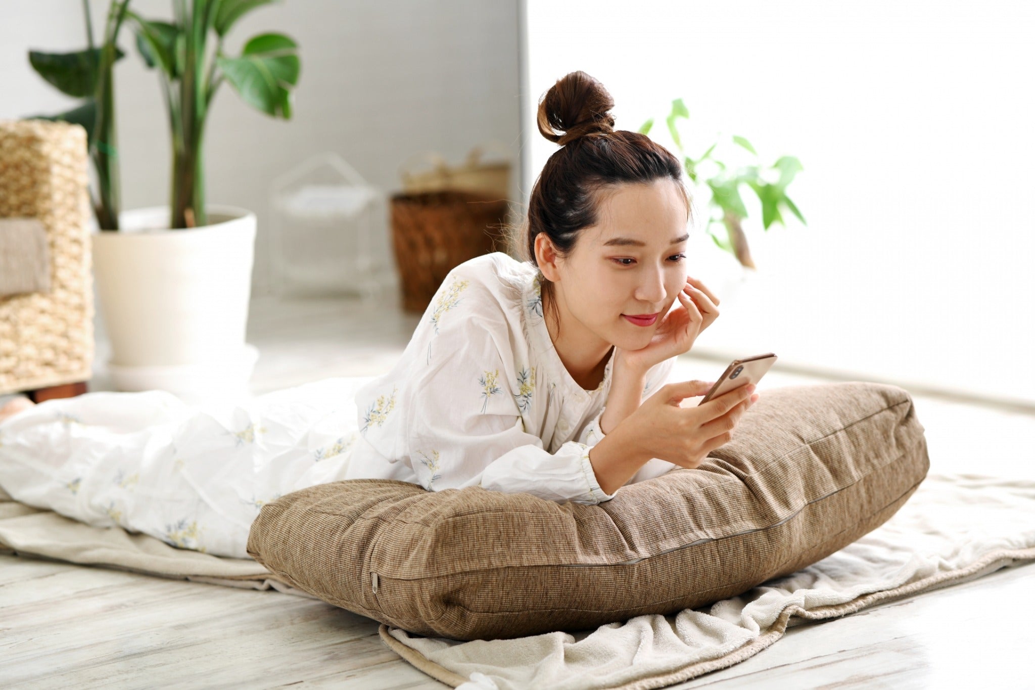 Woman relaxing at home in Bangkok condominium using smartphone during single life lifestyle